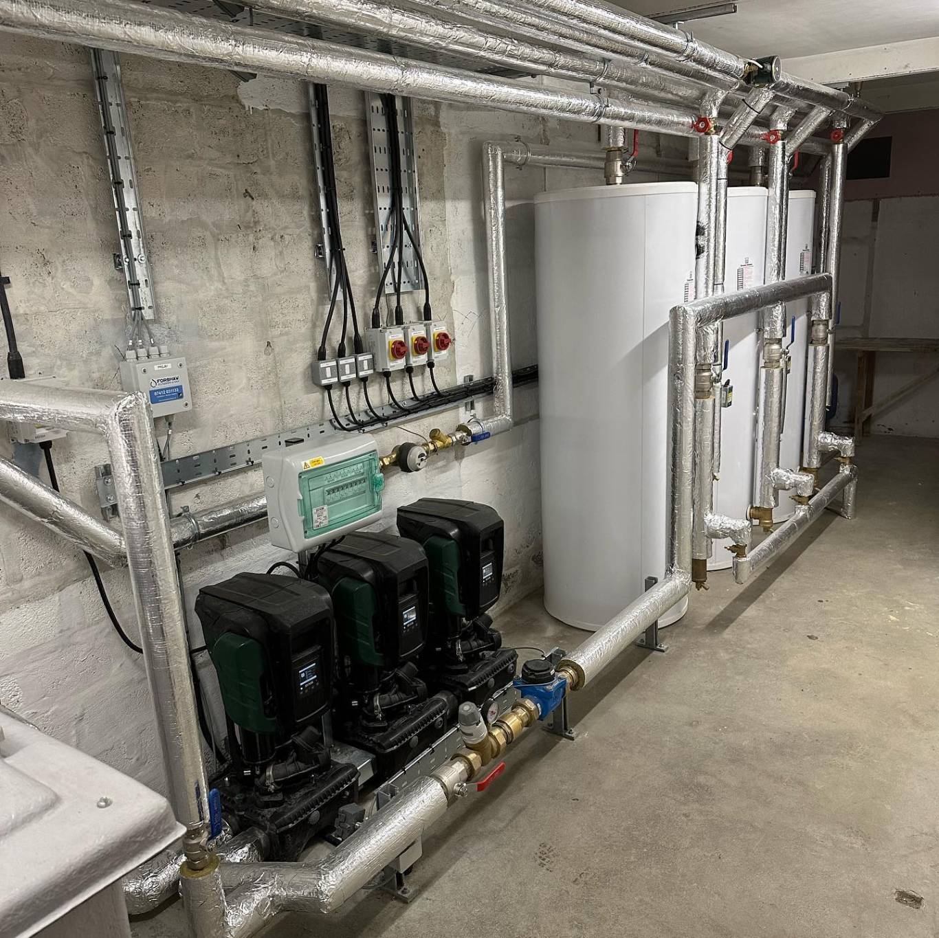 Plant room installed by Forshaw Water & Gas, with booster set, calorifiers and insulated pipework