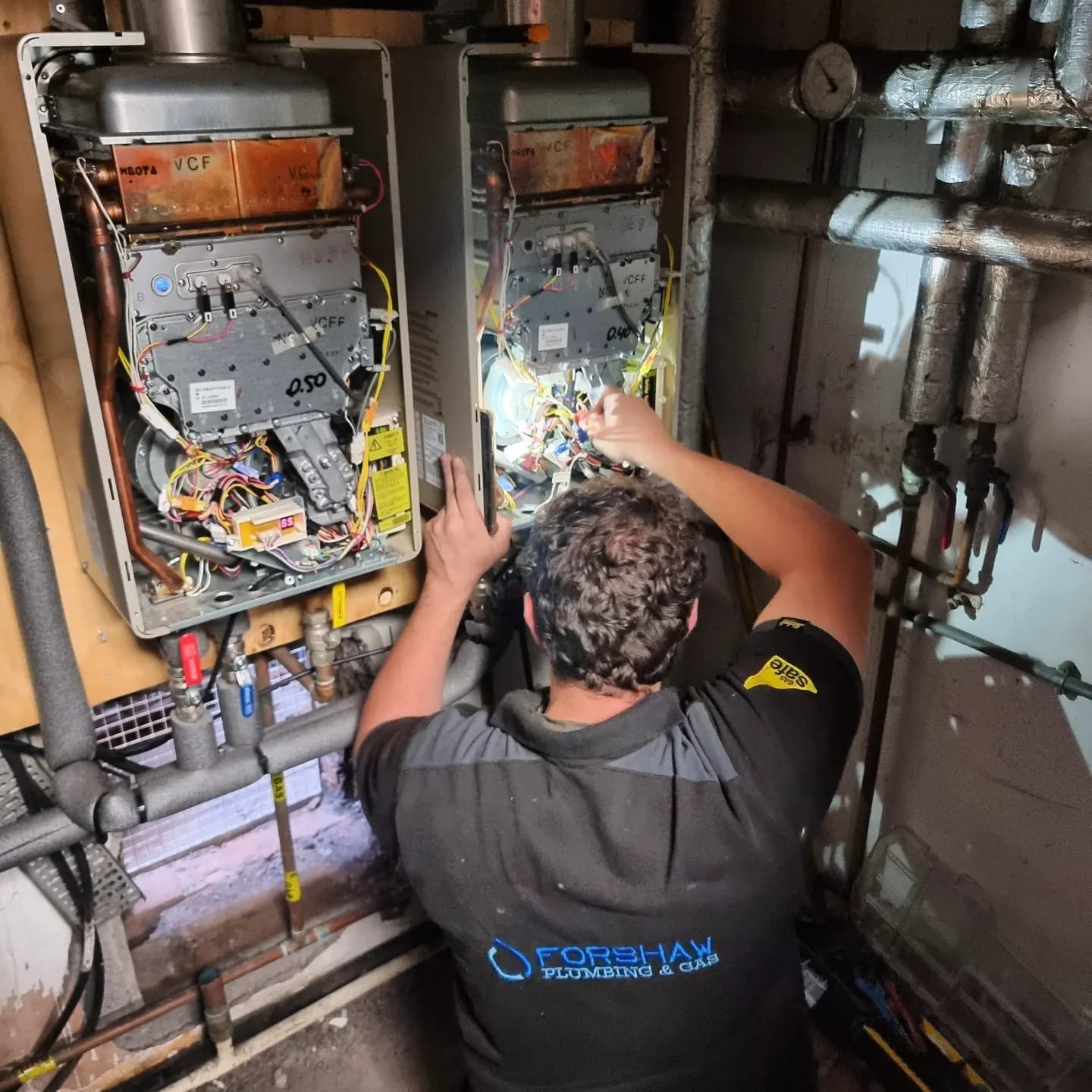 Forshaw engineer servicing twin wall mounted commercial boilers